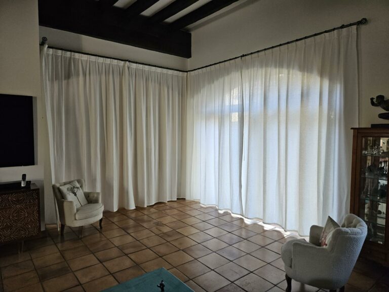 Confection de rideaux sur mesure, tissu blanc 100% Lin. Avec une tringle acier qui épouse la forme du mur en utilisant des coudes arrondis.