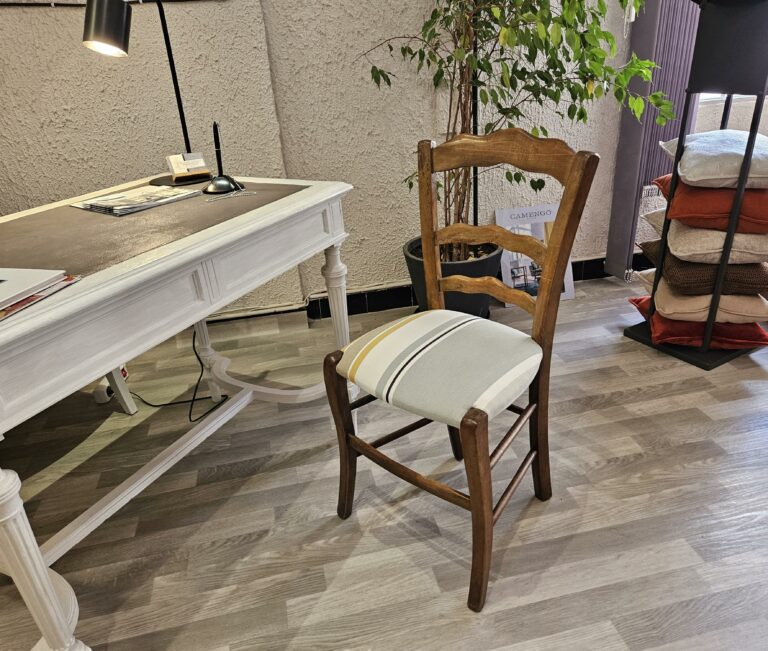 Chaise paillée transformée en assise bultex, recouverte d'un tissu rayé dans des couleurs neutres.